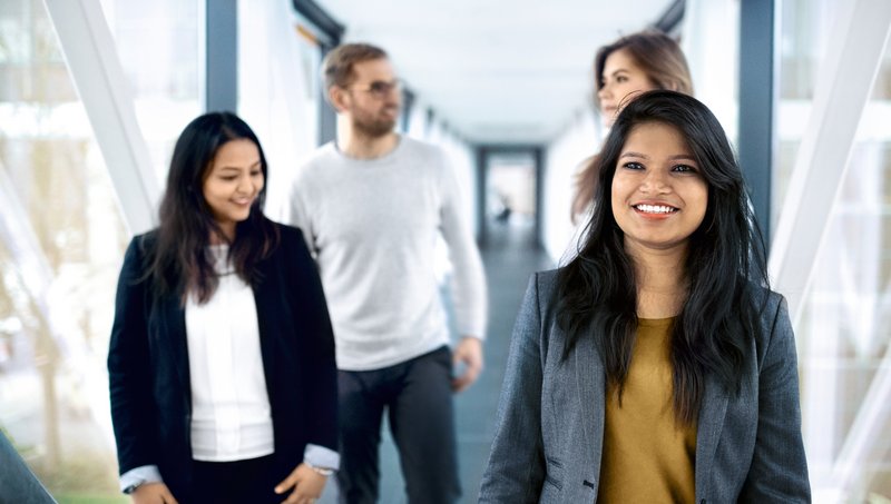 A group of young people walk down a corridor