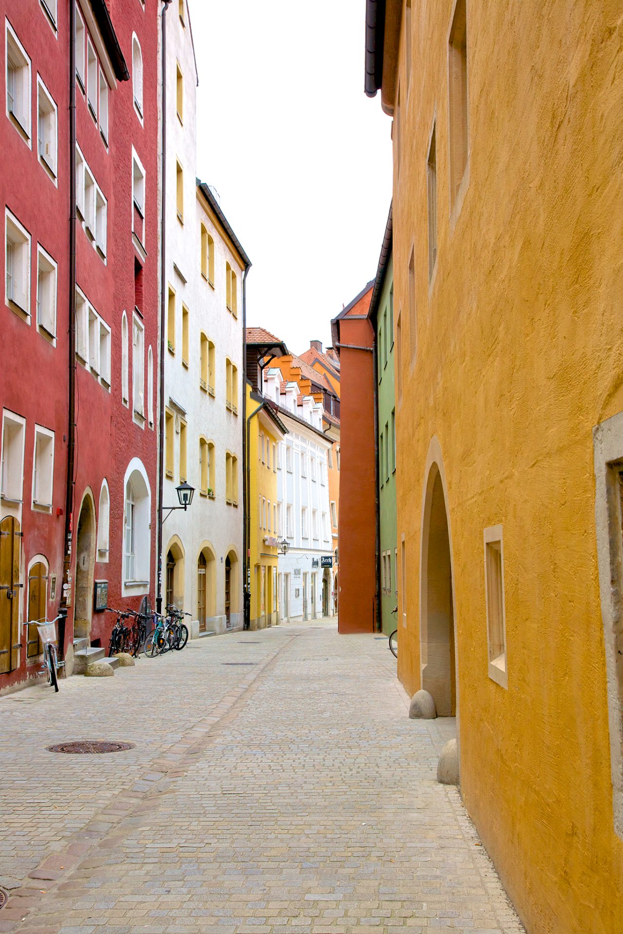 Colorful painted facades on charming cobblestone pedestrian street in Old Town of Regensburg, a Bavarian city on Danube River in southeast Germany. 