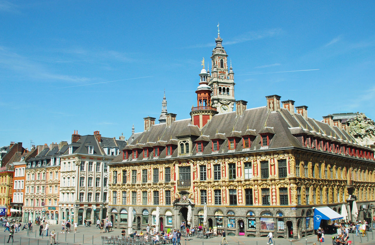 The ornate Vieille Bourse building and surrounding Flemish-style architecture in Lille’s Grand Place under a clear blue sky. 