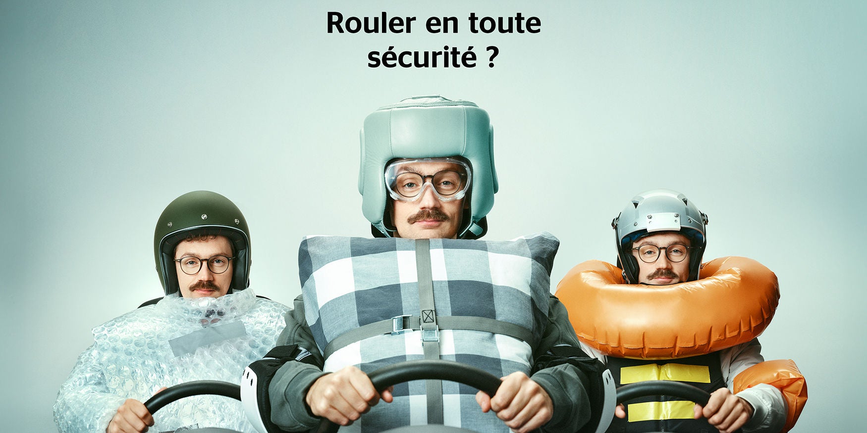 Un homme derrière le volant de sa voiture, entouré de différents dispositifs de sécurité (coussins, film à bulles, bouée). Titre : Rouler en toute sécurité ?