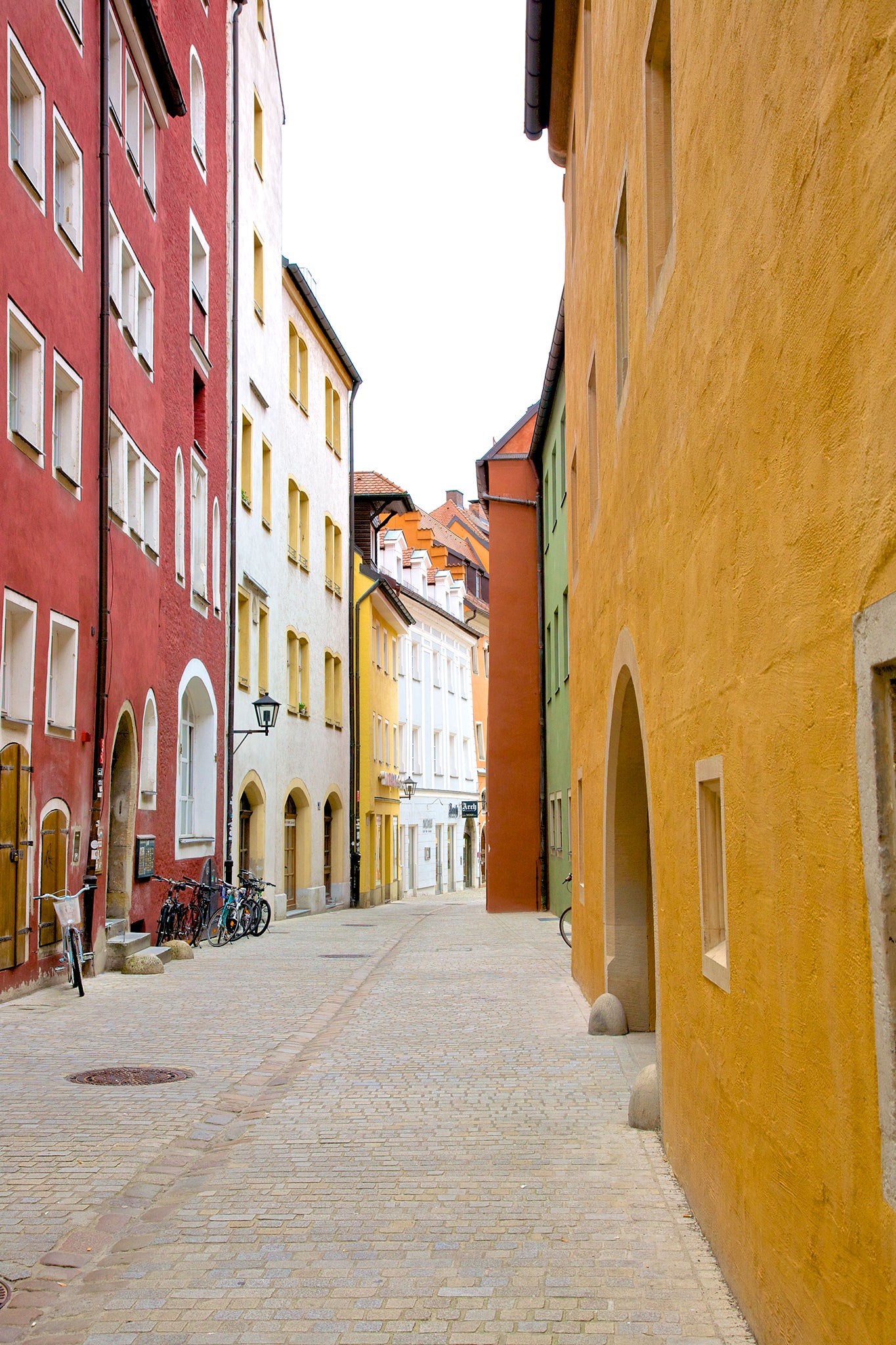 Colorful painted facades on charming cobblestone pedestrian street in Old Town of Regensburg, a Bavarian city on Danube River in southeast Germany. 