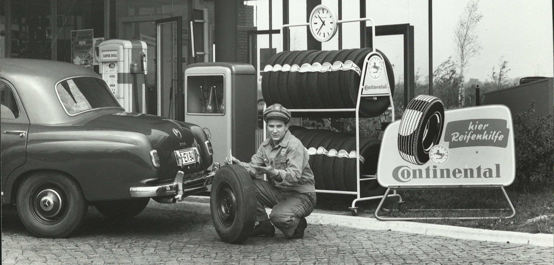 Person changing a tire, black and white image