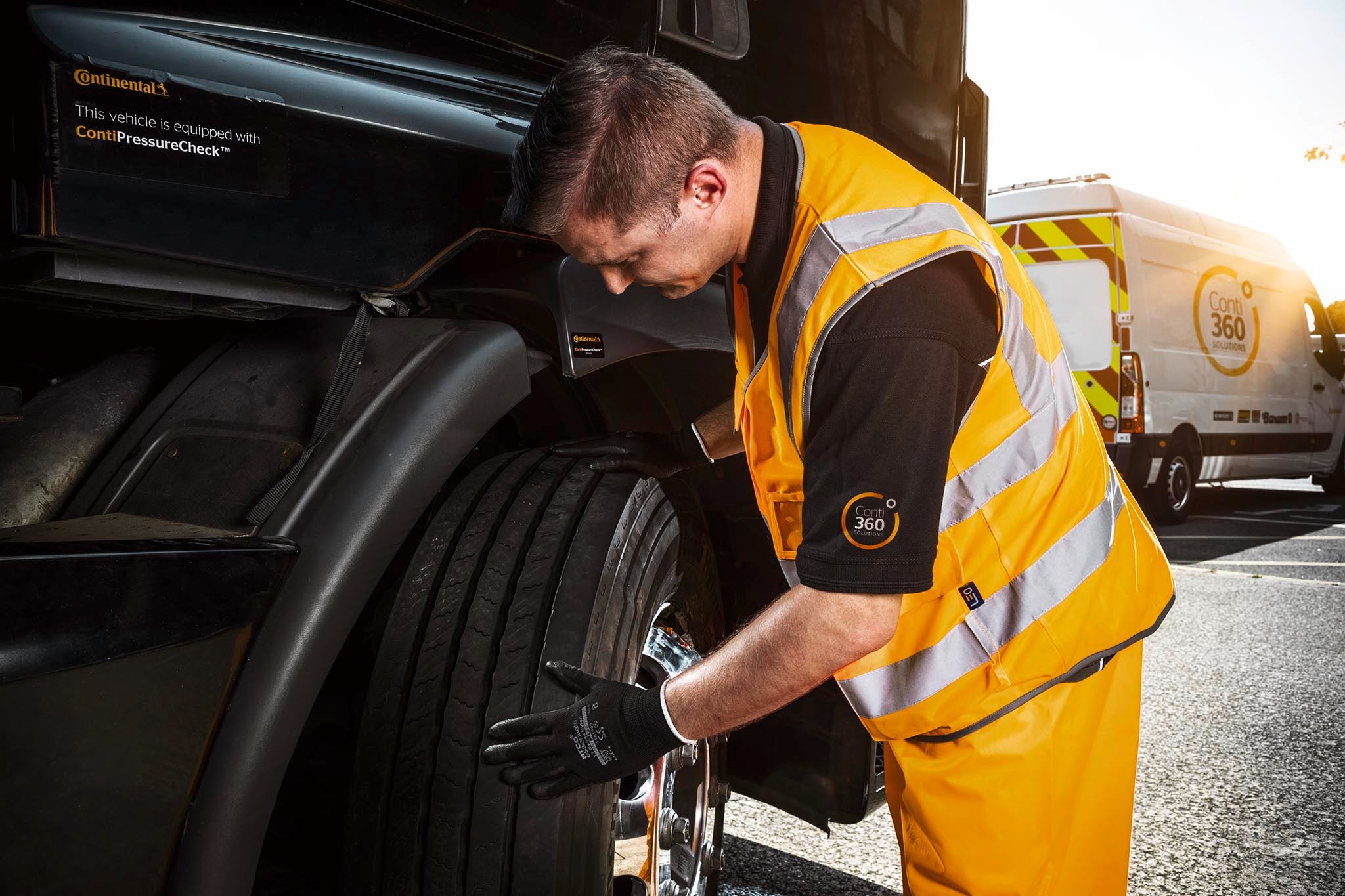 A man from the Conti360 Breakdown service inspects a truck tire