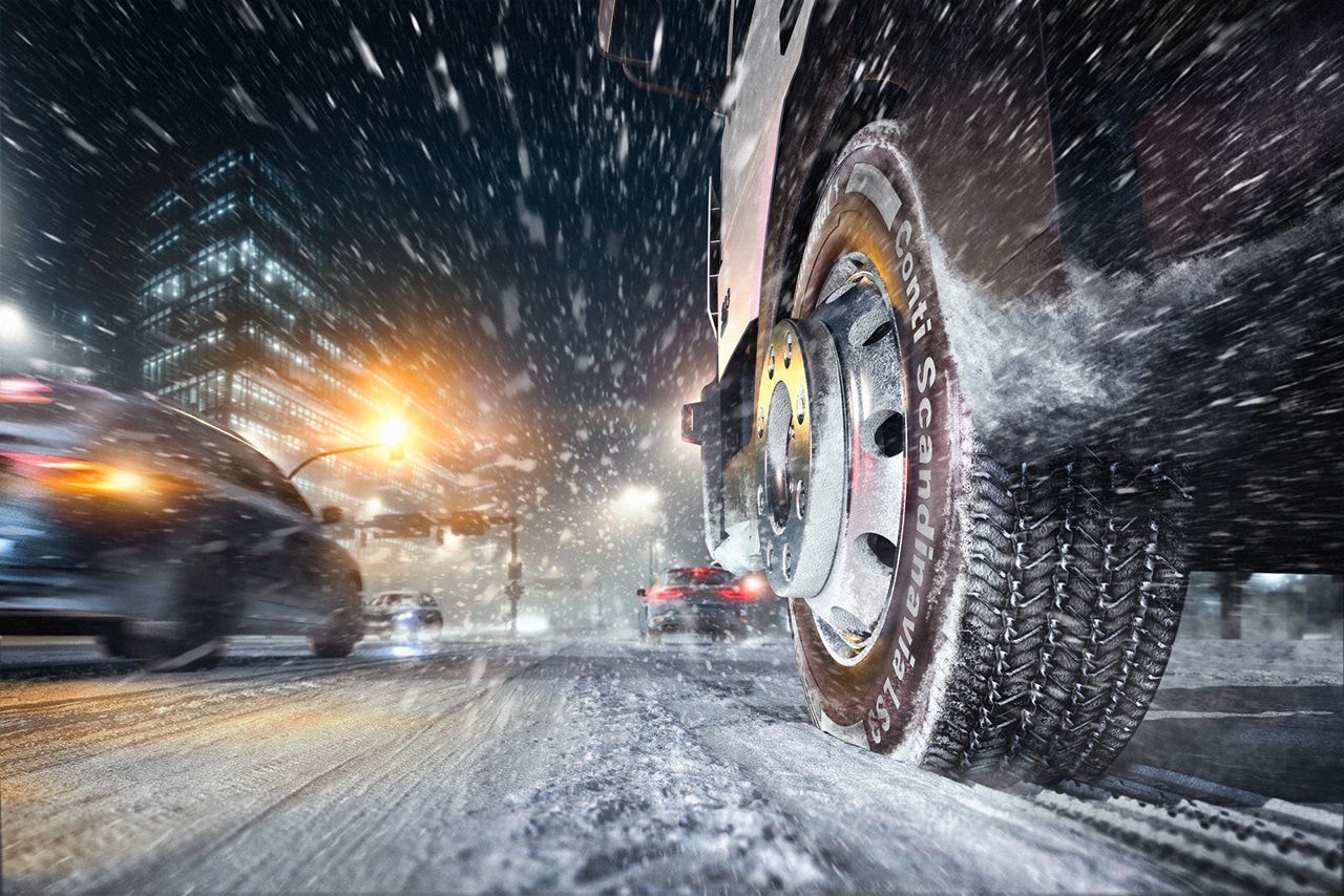 Truck driving in the city in snow