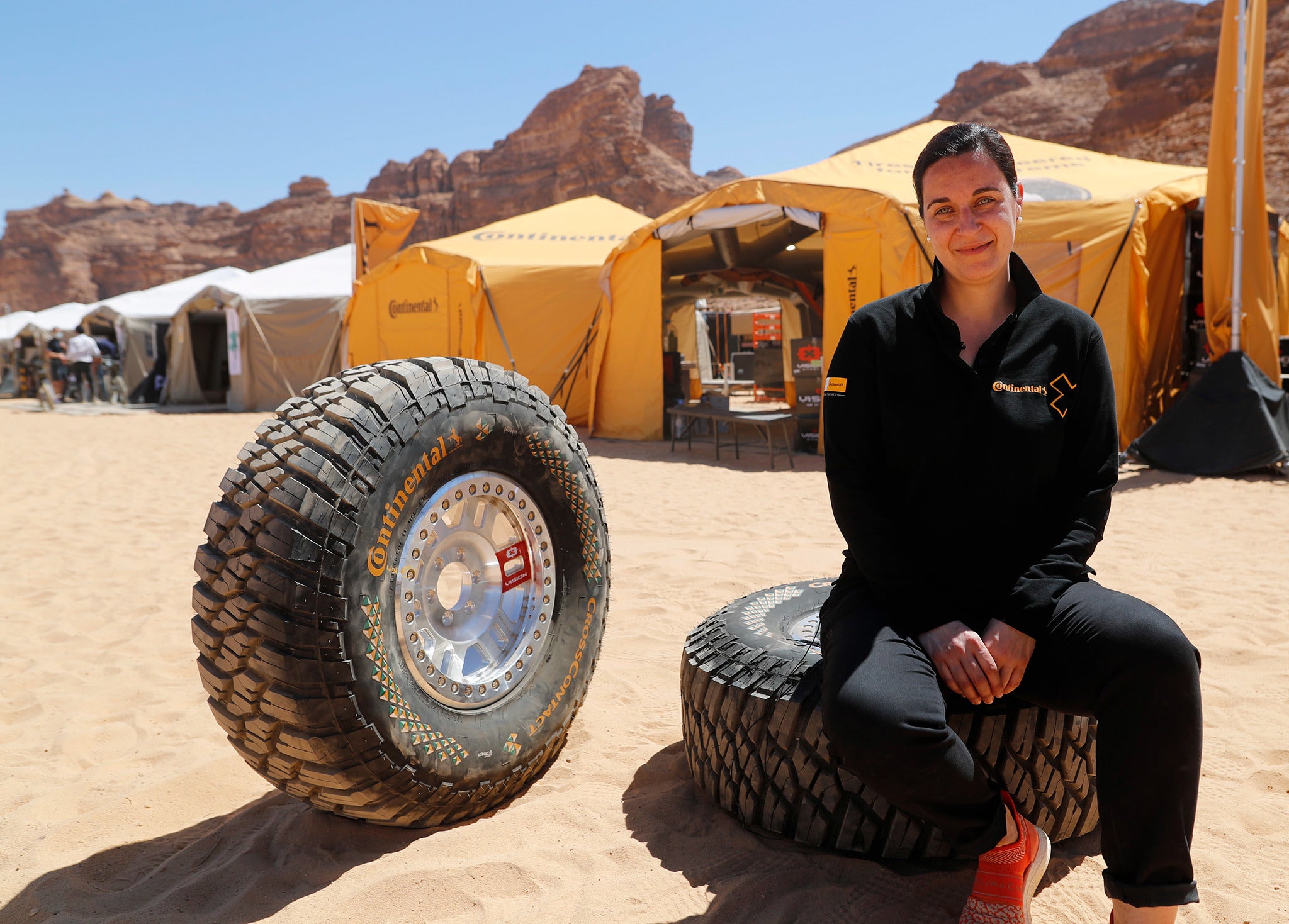 Catarina Silva sentada com os pneus Continental utilizado na prova Extreme-E, no primeiro local da corrida: AIUIa, Arábia Saudita