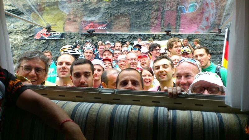 Fans som försöker få en glimt av en TV som visar loppet i en husbil vid Alpe d’Huez, Tour De France © Meinhard Meister