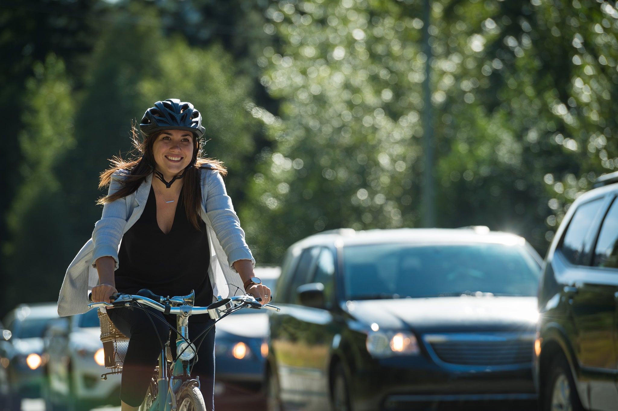 Kvinna som passerar trafik på sin cykel i en cykelbana.