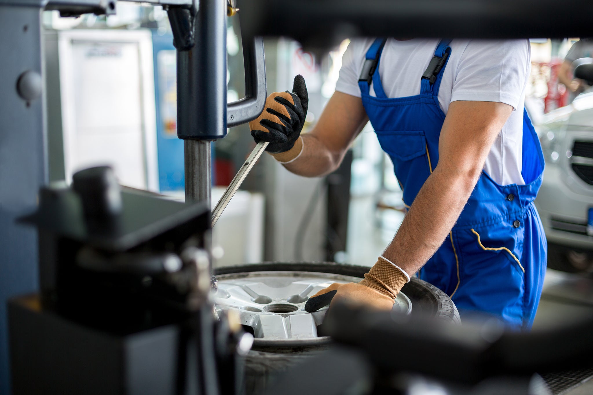 repairman mechanical replace tire on wheel in workshop