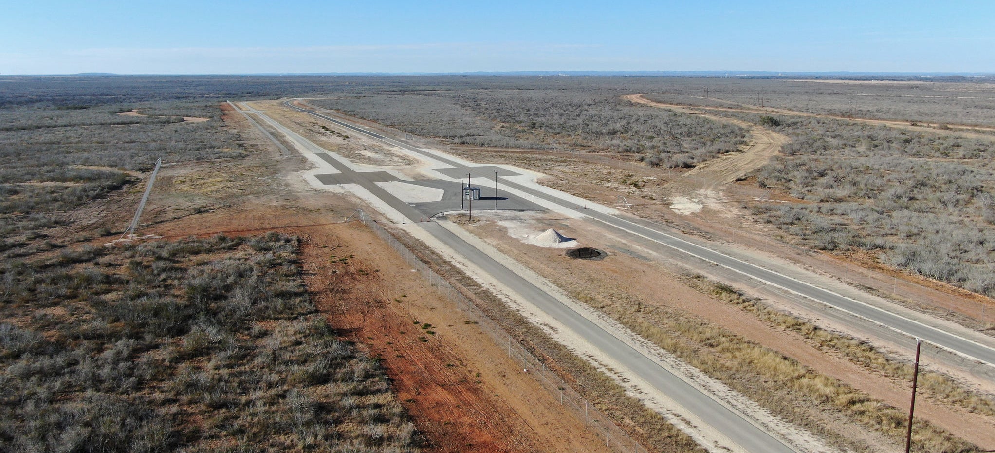 A panoramic view of one of the testing tracks nestled in the expansive desert showcasing a diverse array of surfaces for comprehensive vehicle testing.