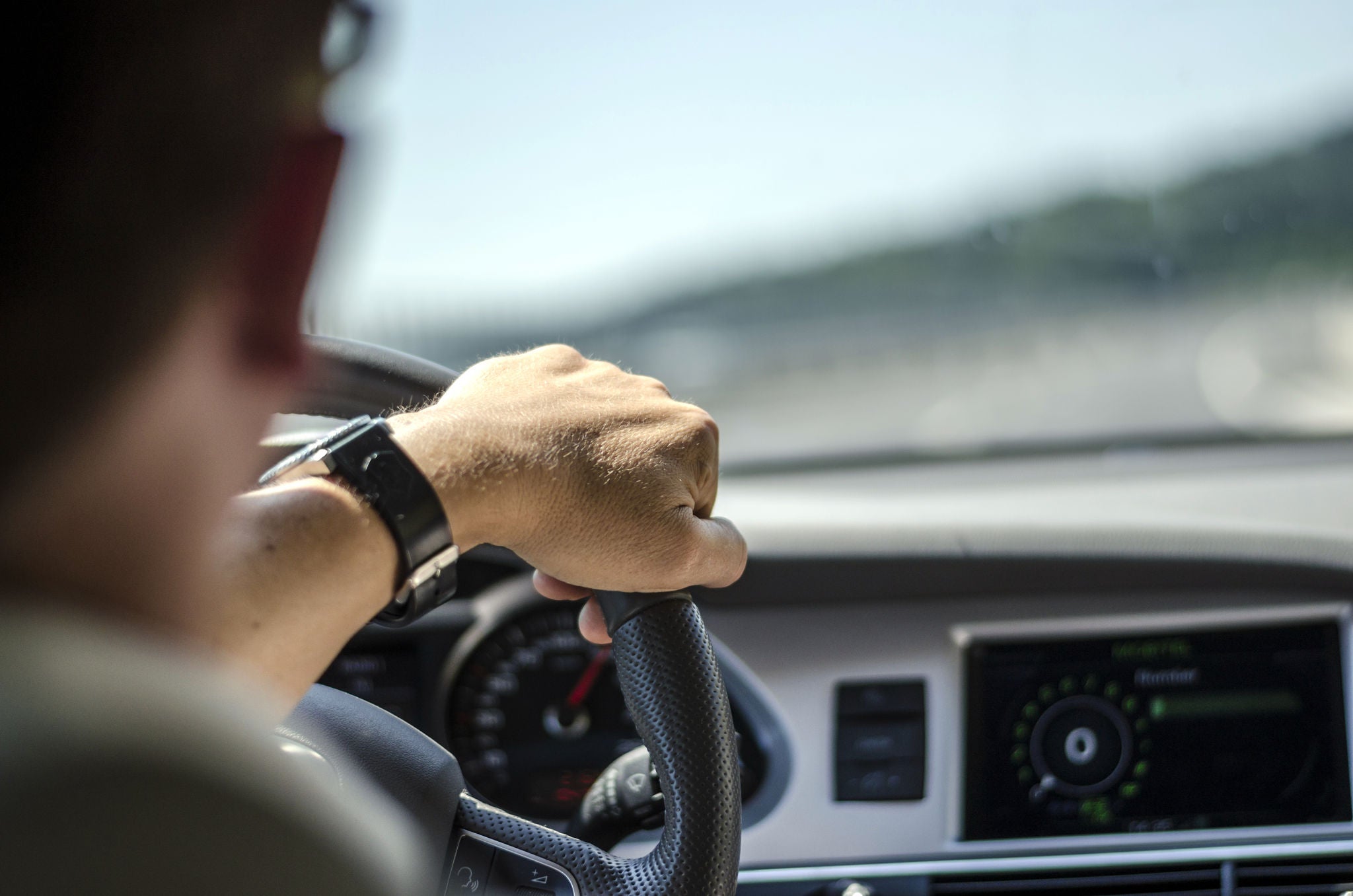 Generic photo of man driving a car through slight turn.; Shutterstock ID 152454830; purchase_order: -; job: -; client: -; other: -