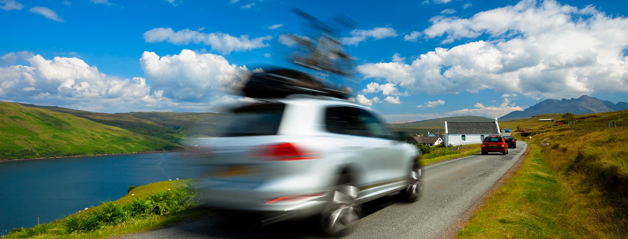 car driving with bike on roof on Isle of Skye; Blurred Motion, Scotland, UK,click below to view more related images: