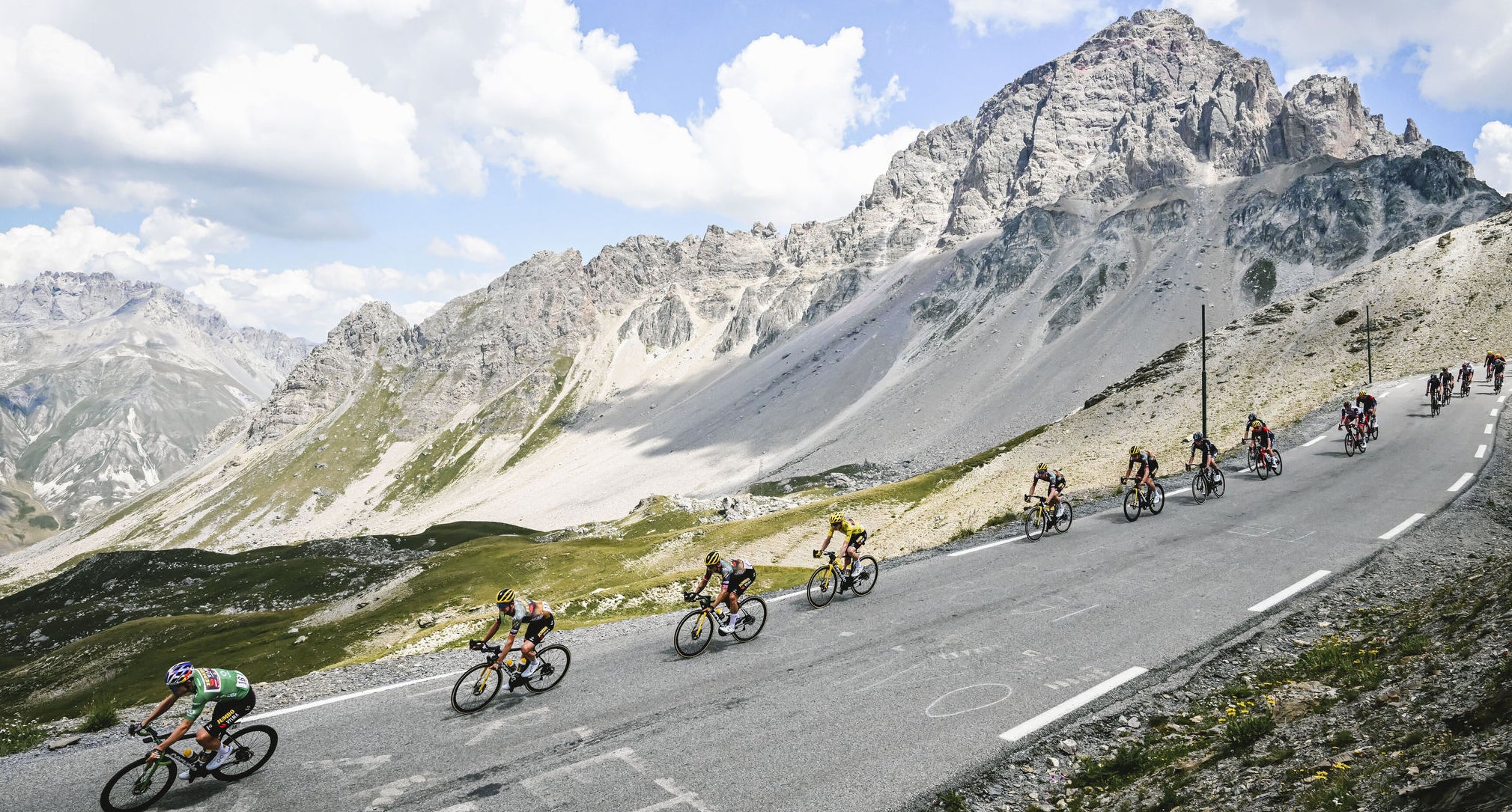 cyclists ride down a hill and take a corner