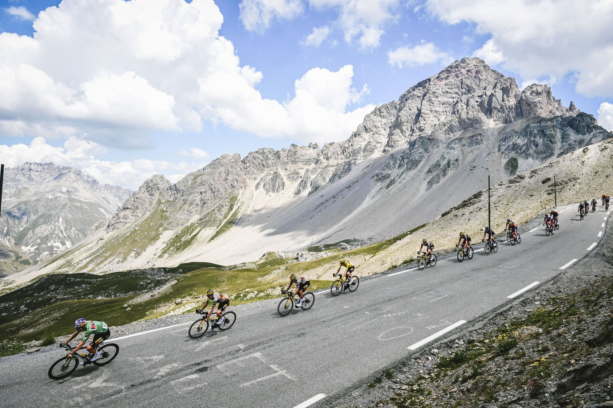 cyclists ride down a hill and take a corner