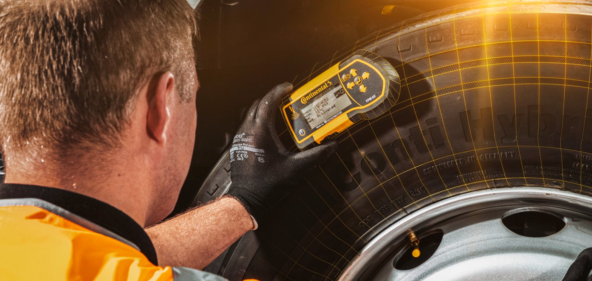 A man from the Conti360 Breakdown service inspects a truck tire