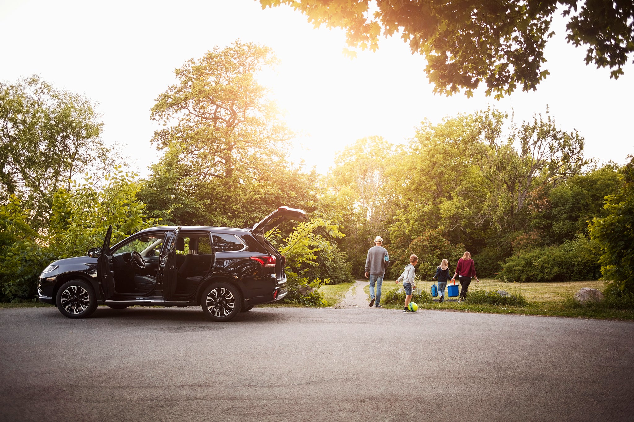 A family arrived an their holiday home and is unloading their car.