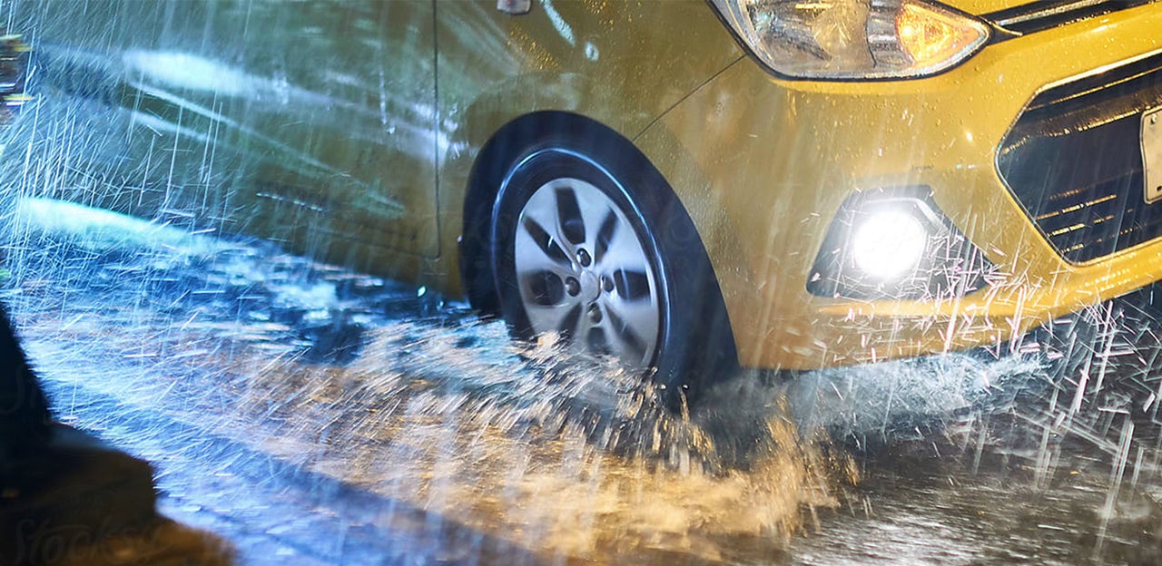 Car driving in heavy rain