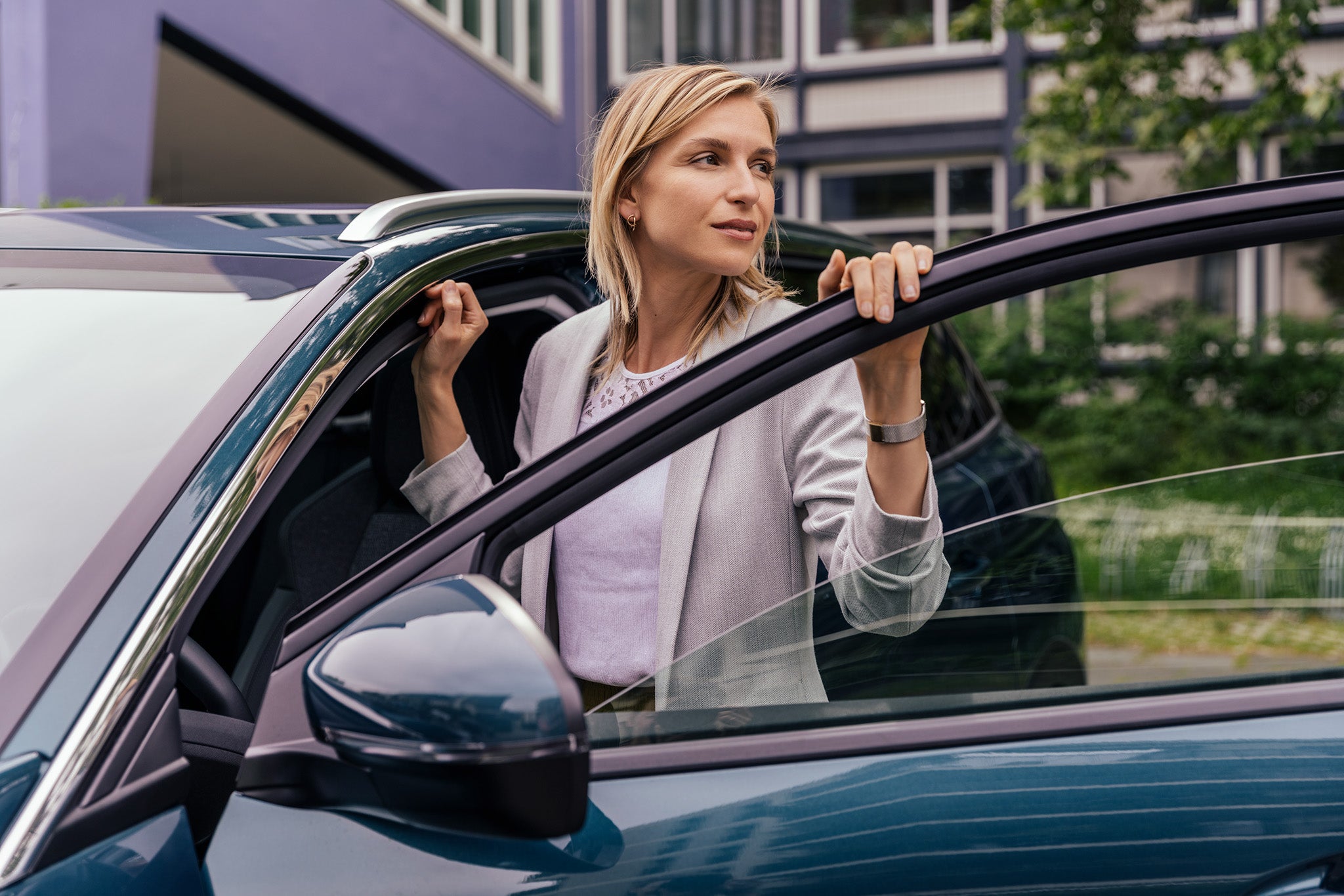 Woman leaning at open car door, Cologne, NRW, Germany