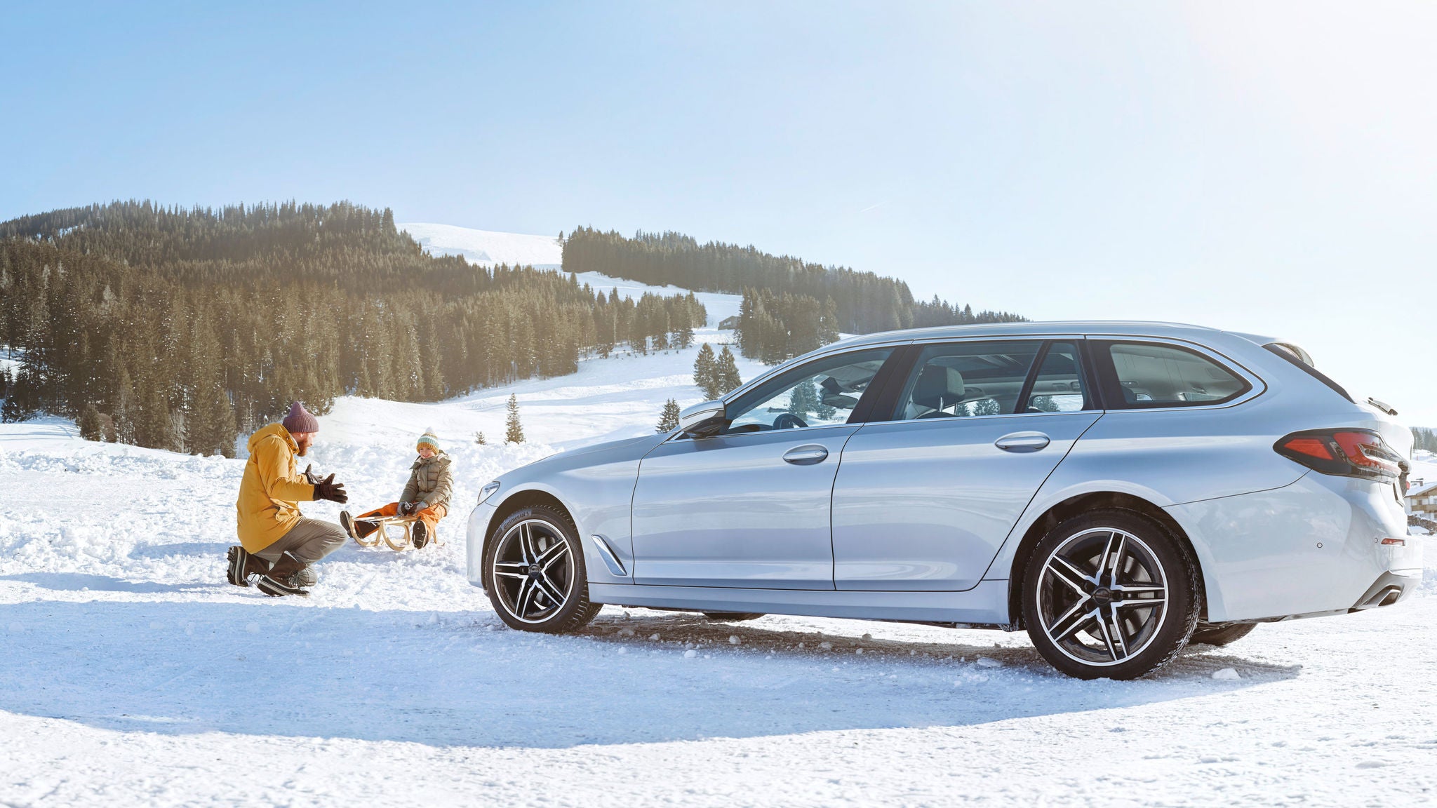 Car in snow with father and child