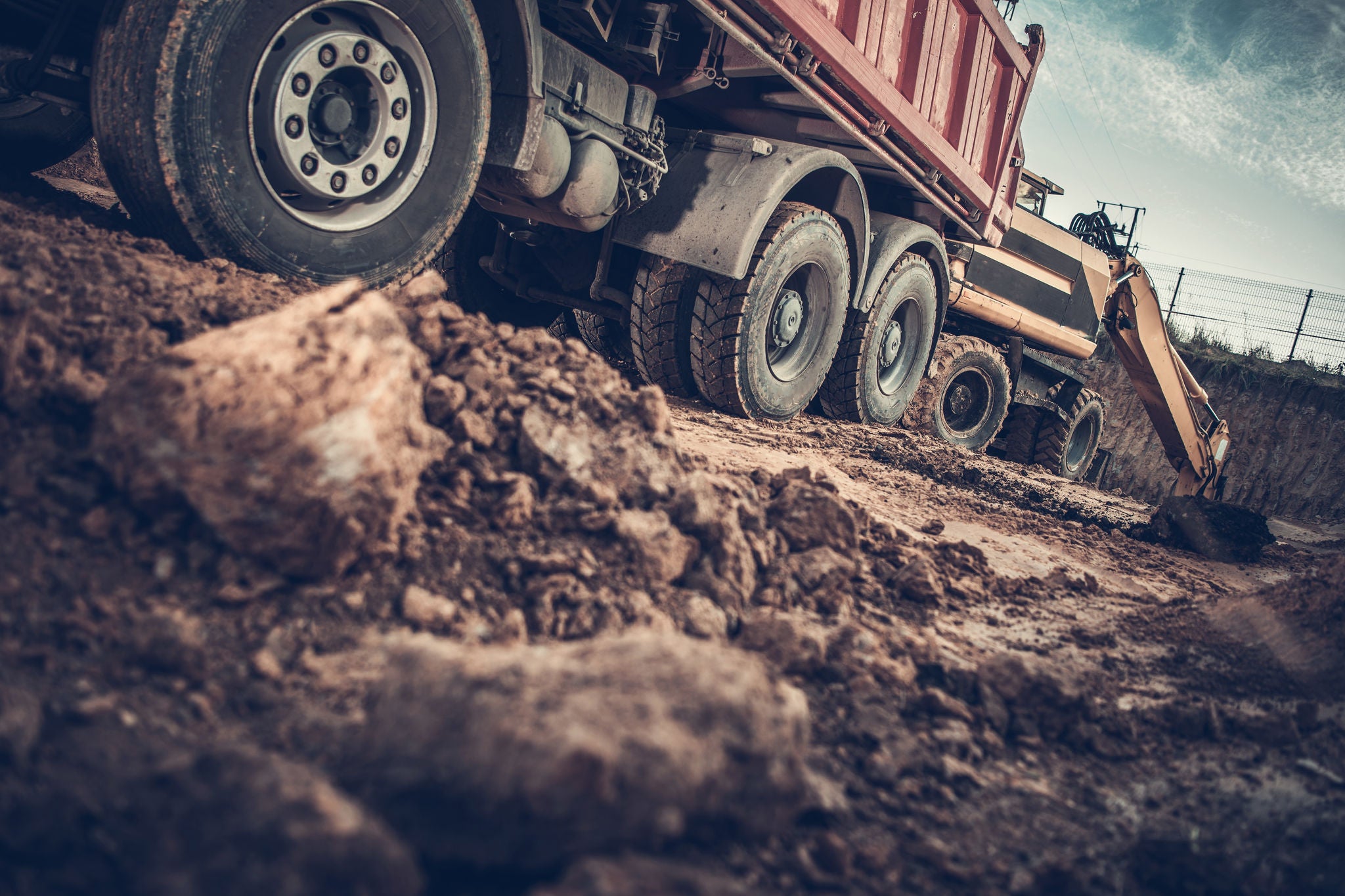 Ground Works Construction Site. Excavator Loading Dump Truck with Soil. 