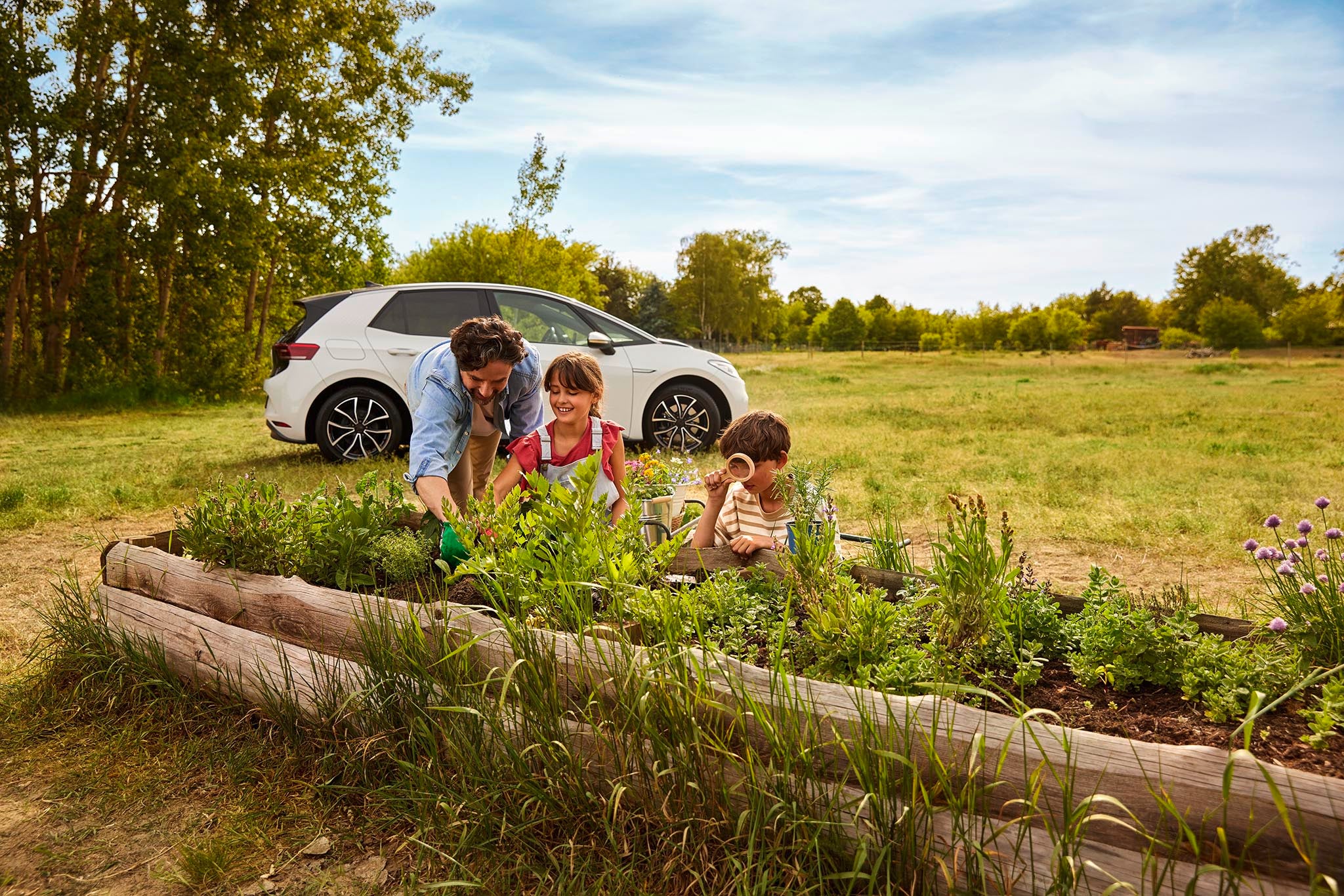 Family in a garden with a car