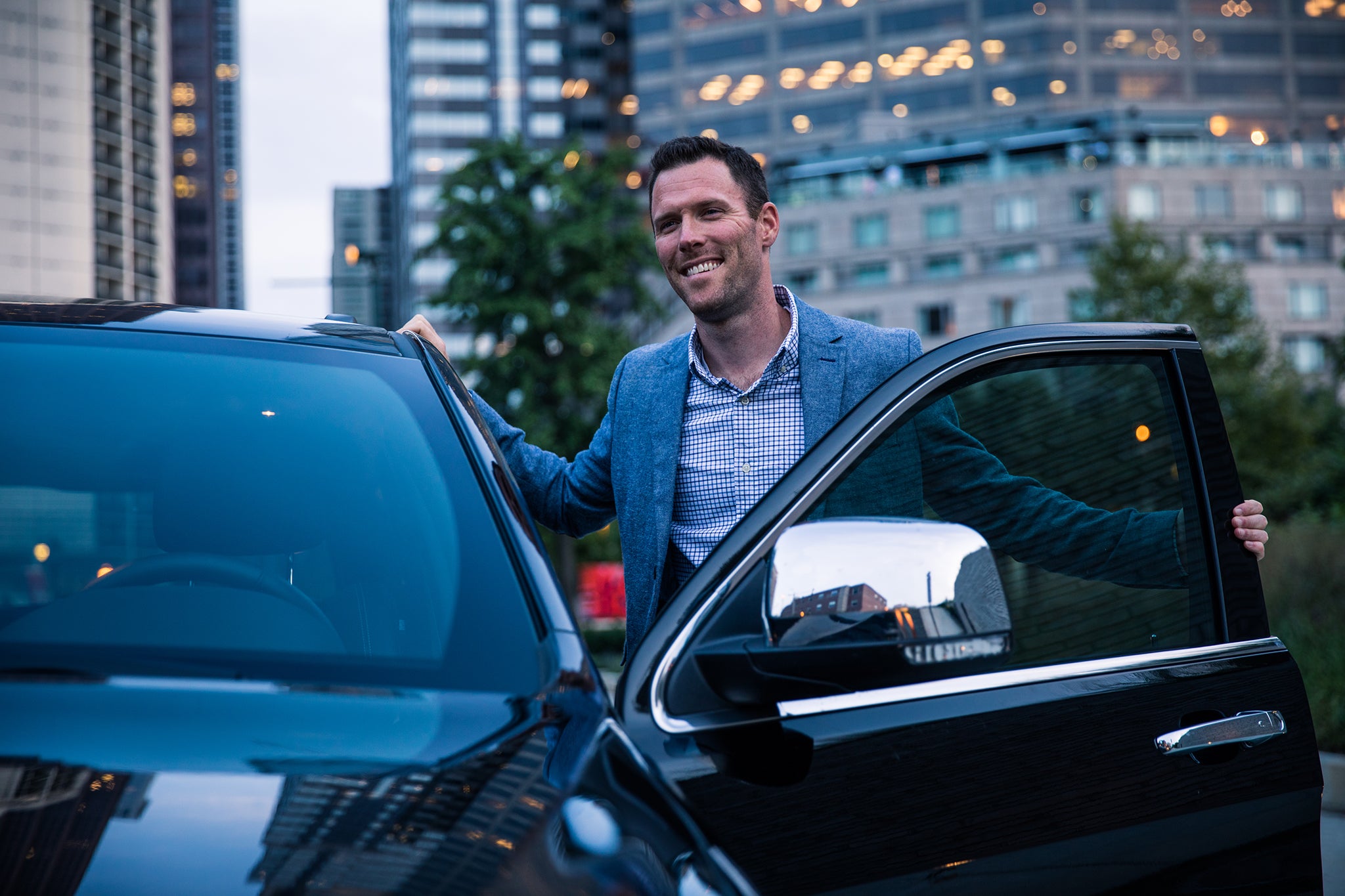 A man standing next to his car with the door open.