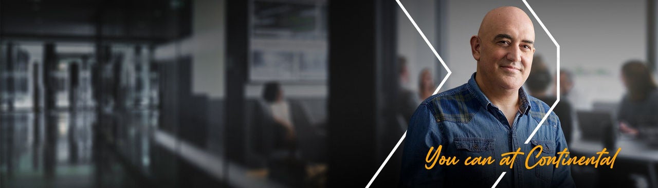 A man in a denim shirt smiles at the camera with blurred office workers in the background. Text reads, "You can at Continental".