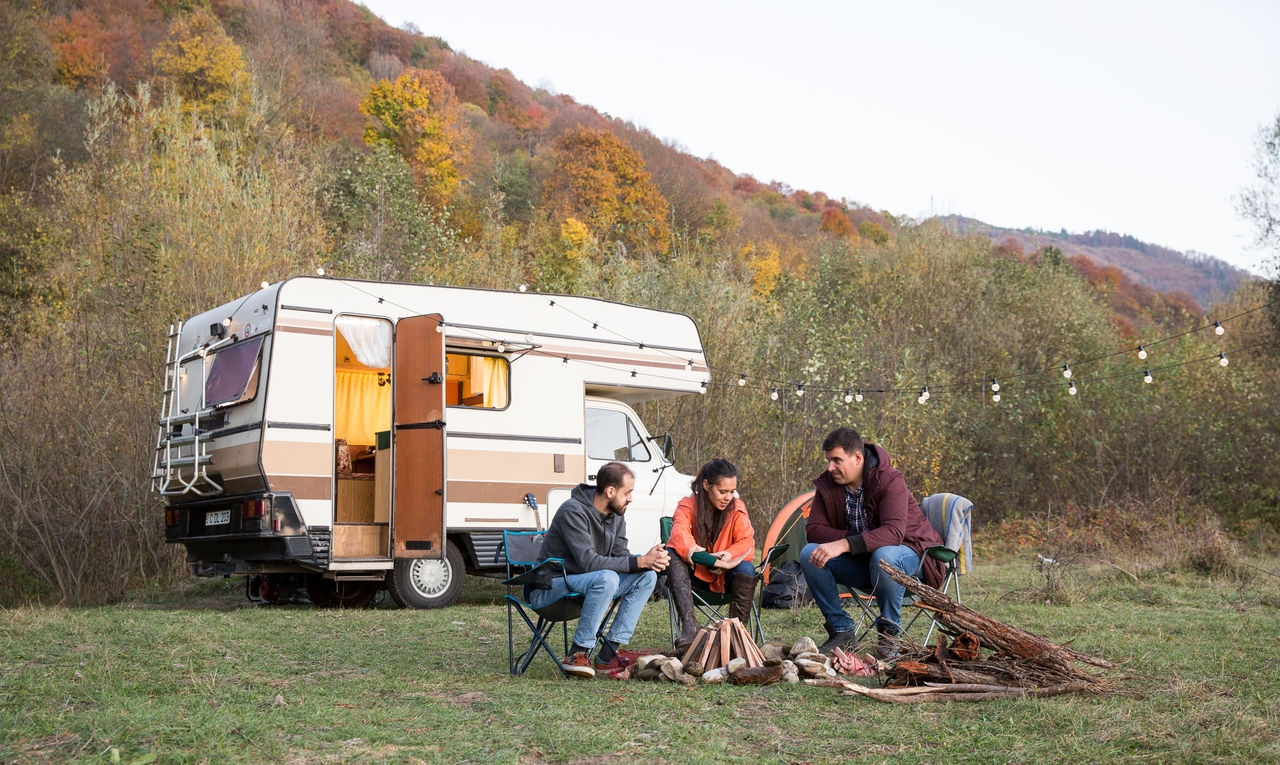 Group of friends enjoying their time together in the mountains Freunde vor Wohnmobil