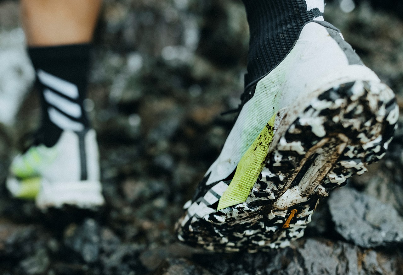 Athlete with Adidas Terrex shoes going in mud.