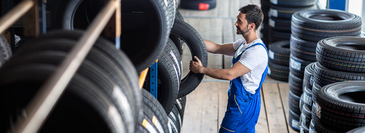 Auto mechanic  choose tire for car at a tire store