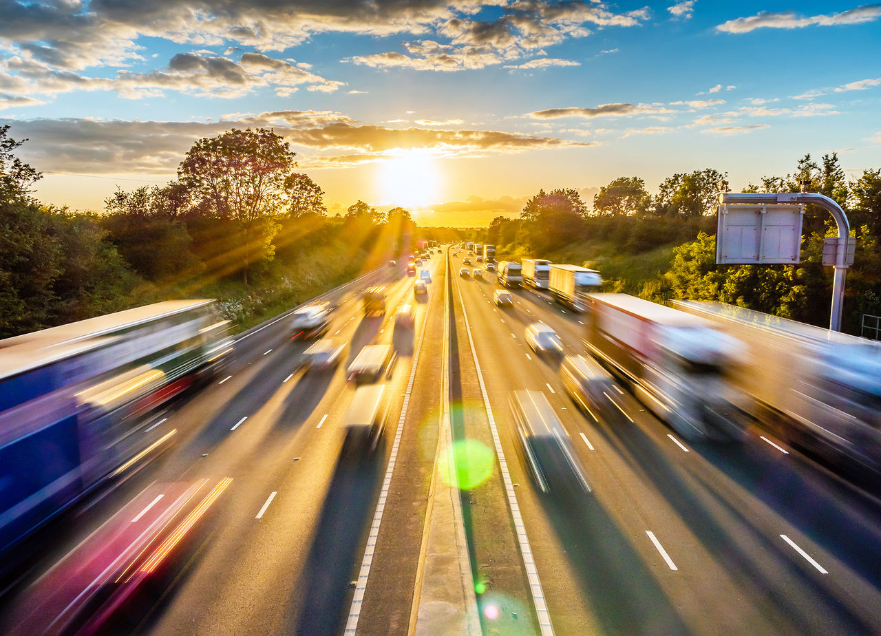 heavy traffic moving at speed on UK motorway in England at sunset.