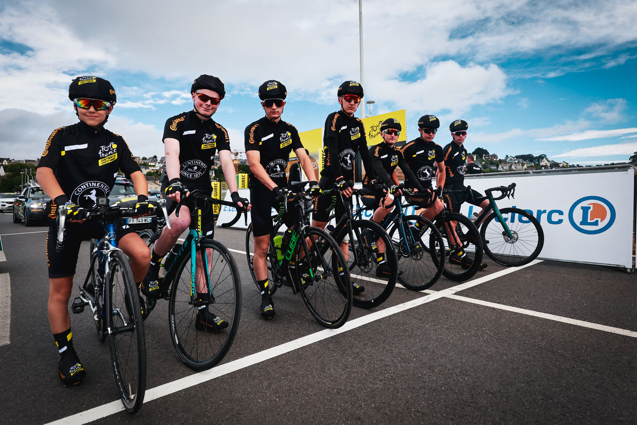 Jóvenes cadetes uniformados en una bicicleta de competición en la línea de salida del Tour de Francia