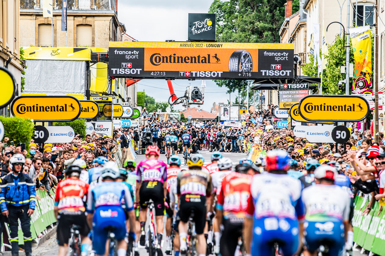 Foto 07/07/2022 - Tour de Francia 2022 - Etapa 6 - Binche / Longwy (219,9 km) - Calle con muchos carteles de la marca Continental y muchos ciclistas compitiendo