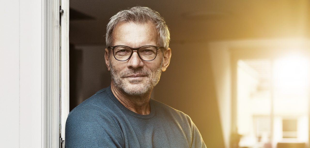 A fleet manager wearing glases at the door of his office