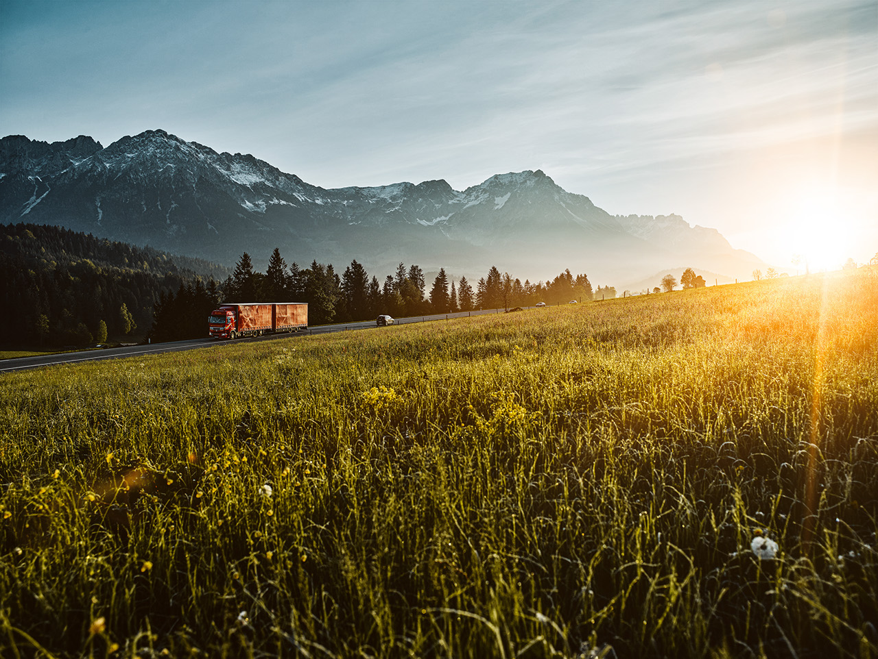 Fields by sunset with a orange truck in background