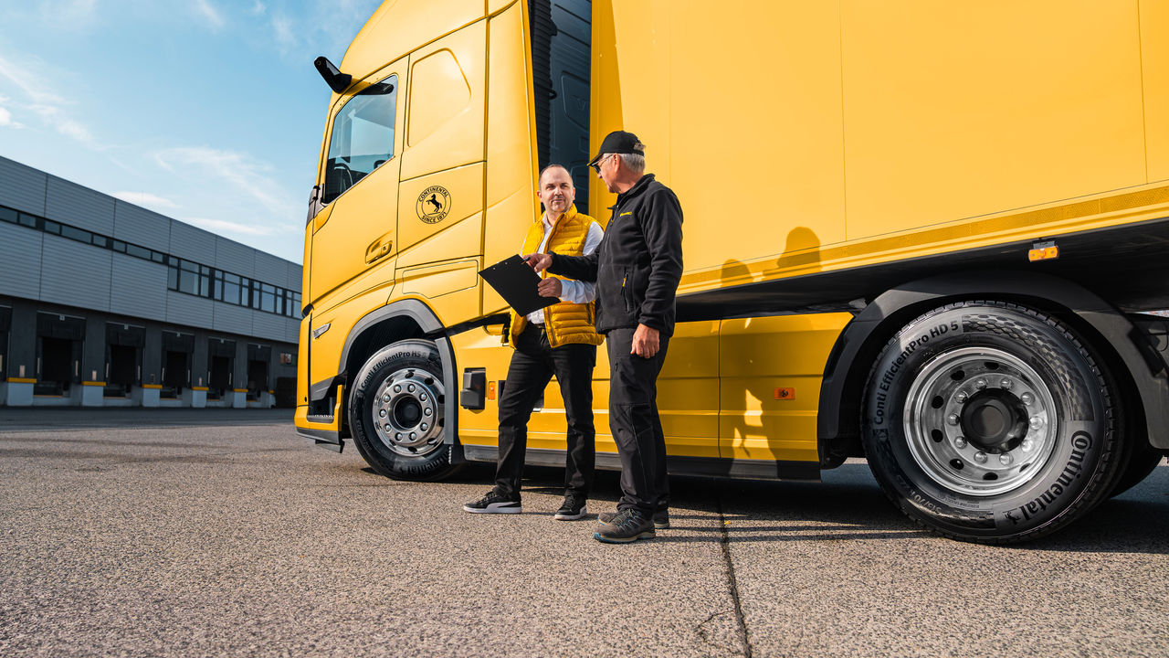 Two persons in front of a truck
