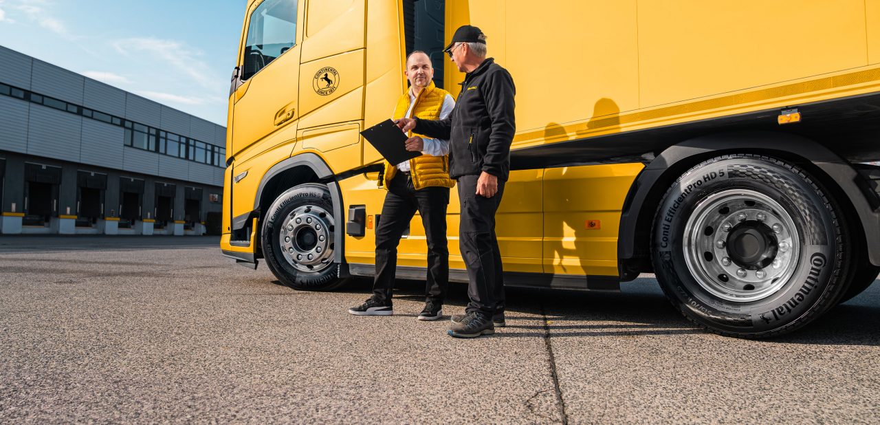 Two persons in front of a truck