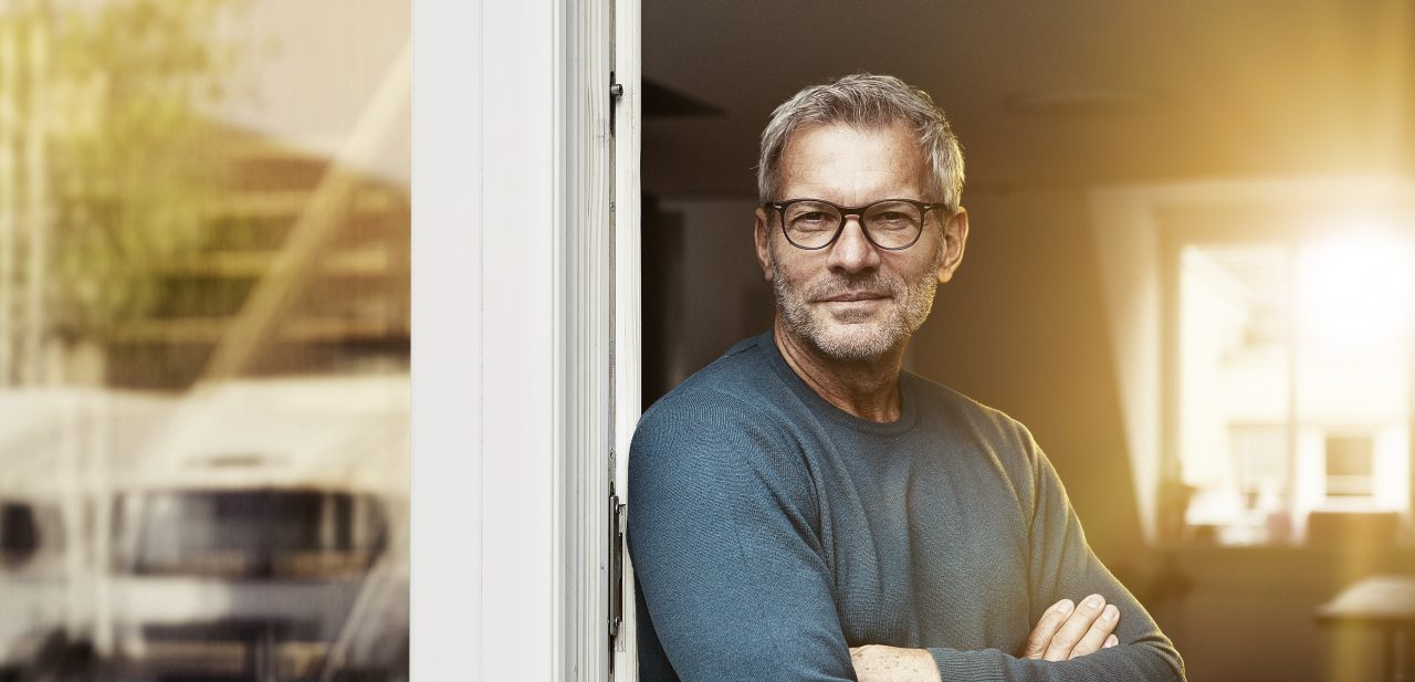 A fleet manager wearing glases at the door of his office