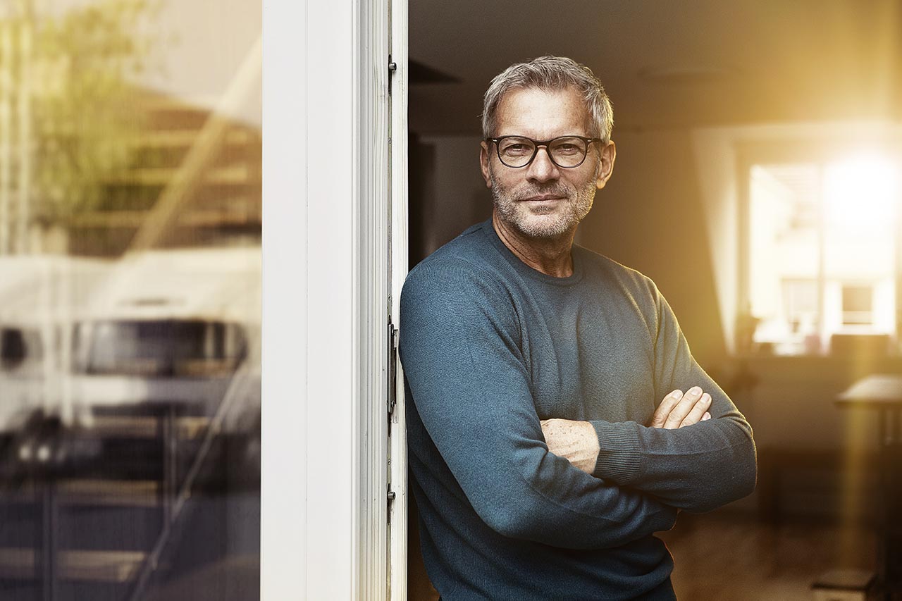 A fleet manager wearing glases at the door of his office
