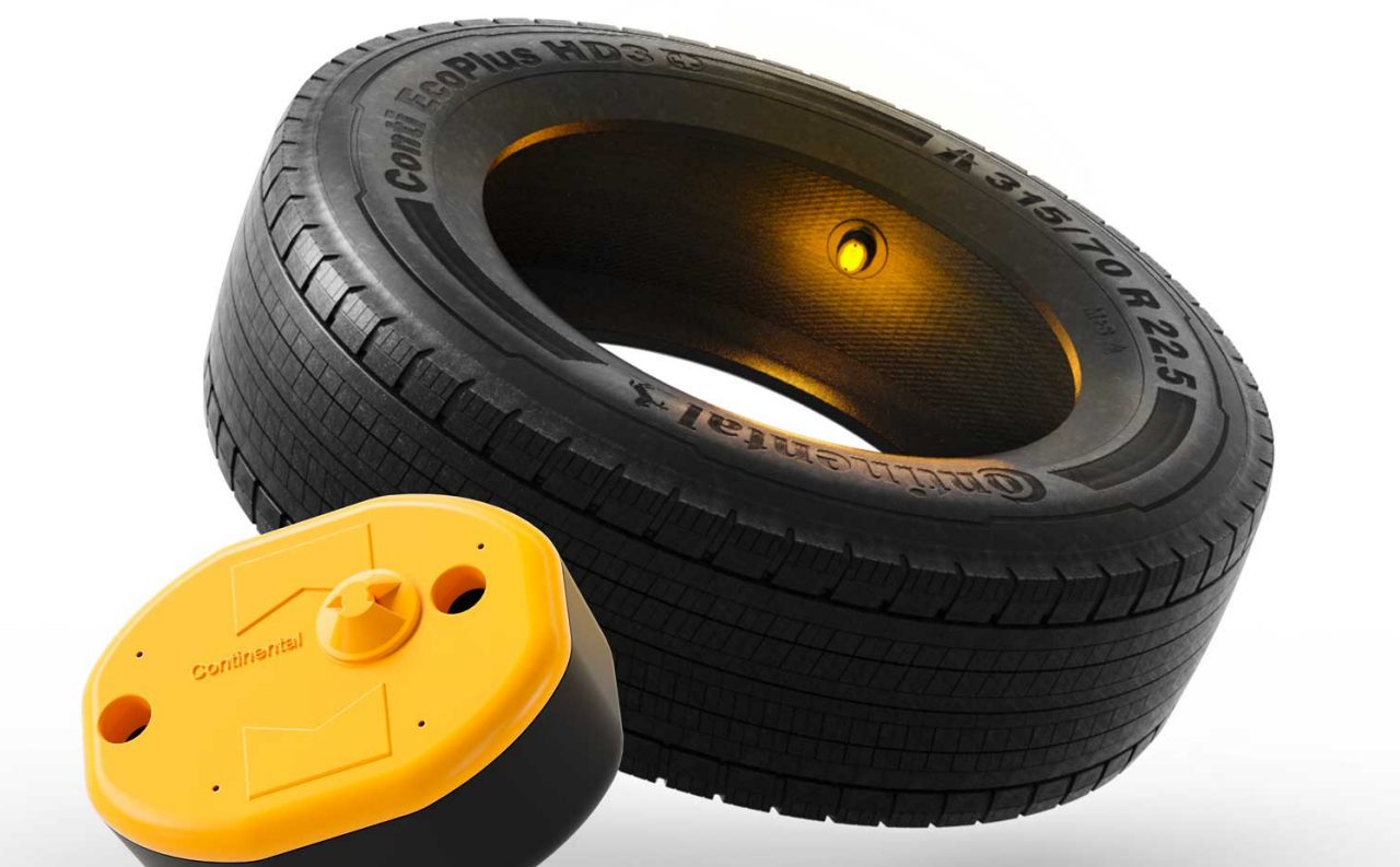 (Llanta Continental HD3 junto a un sensor Continental de llanta, representación de tecnología para el monitoreo de llantas.)