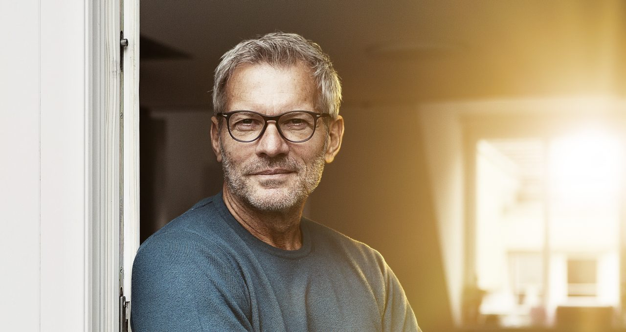 A fleet manager wearing glases at the door of his office