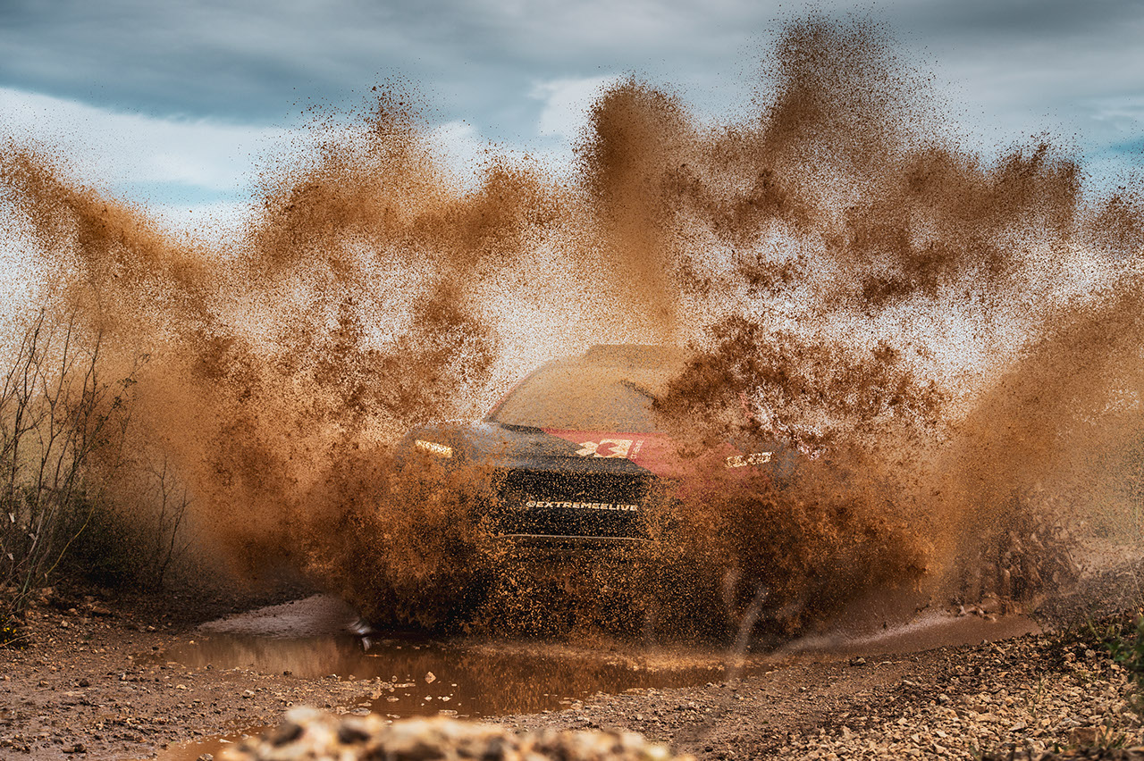 Extreme E race car driving through mud