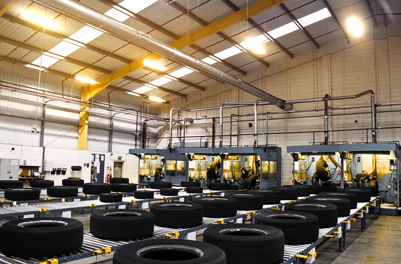 a lot of tires lying on a conveyor belt in a hall