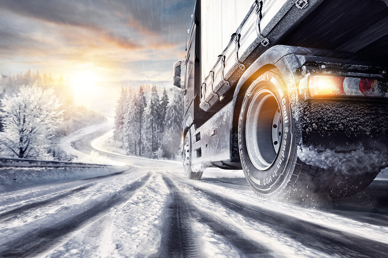 Lastbil kör på en landsväg i snö