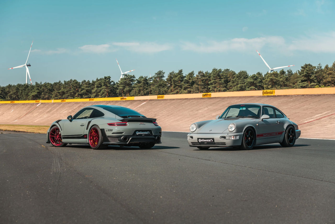 Two grey sports cars on a track 
