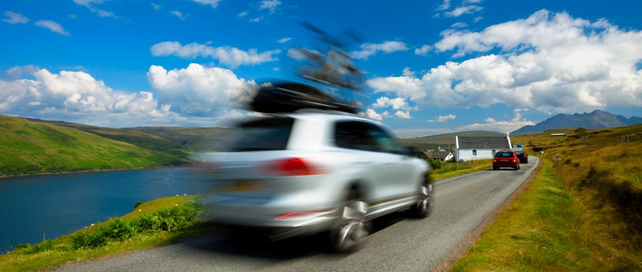 SUV car driving with bike on roof on Isle of Skye; Blurred Motion, Scotland, UK,click below to view more related images:
