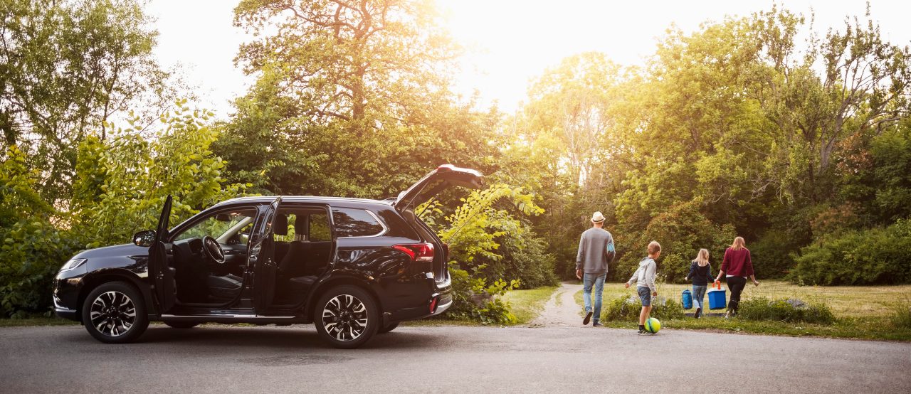 A family arrived an their holiday home and is unloading their car.
