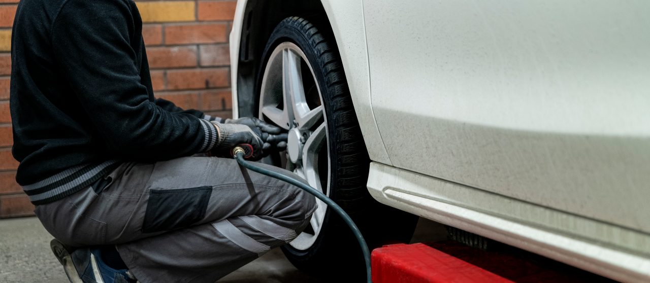 A man is tightening the screws at front tire.