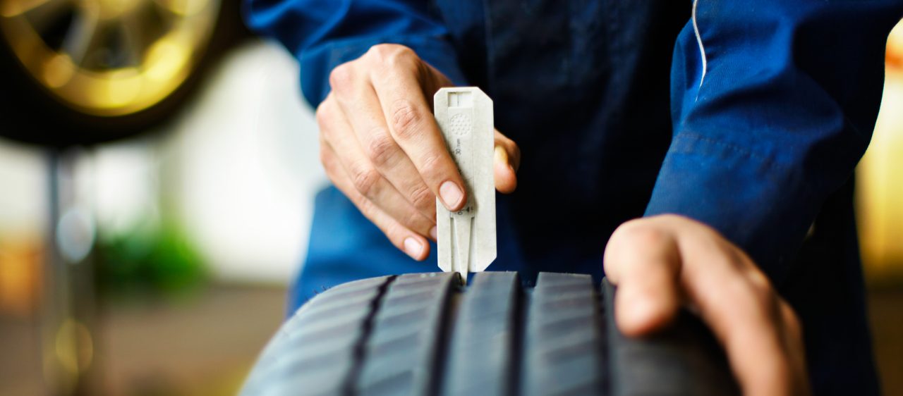 Mechanic checks tread depth