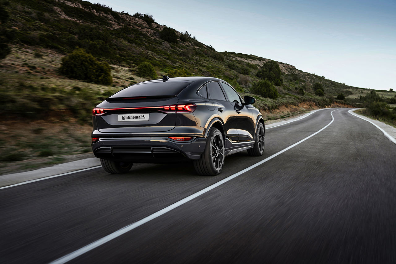 2557253459 Black luxury SUV driving through a winding countryside road at dusk, embodying elegance, performance, and freedom in a serene natural landscape.