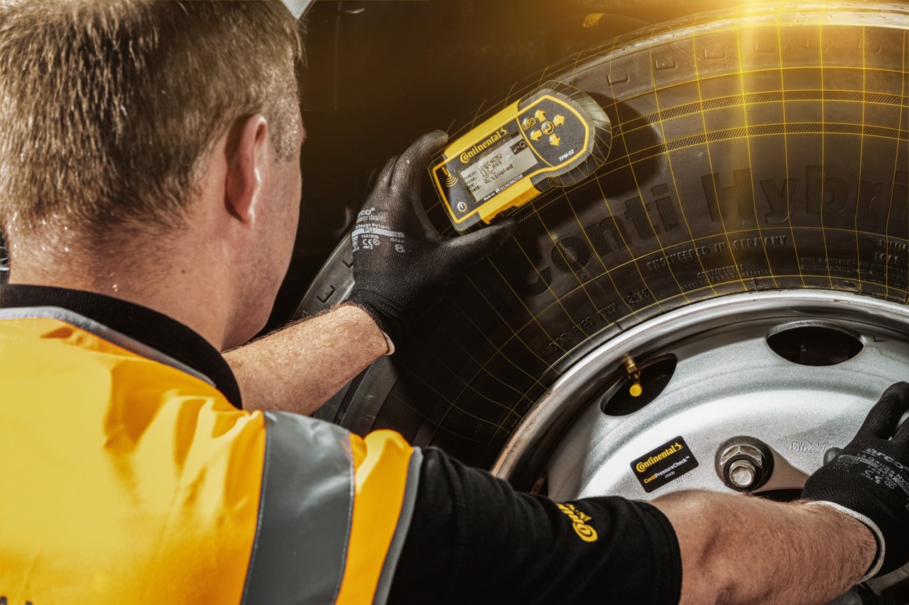 A man from the Conti360 Breakdown service inspects a truck tire